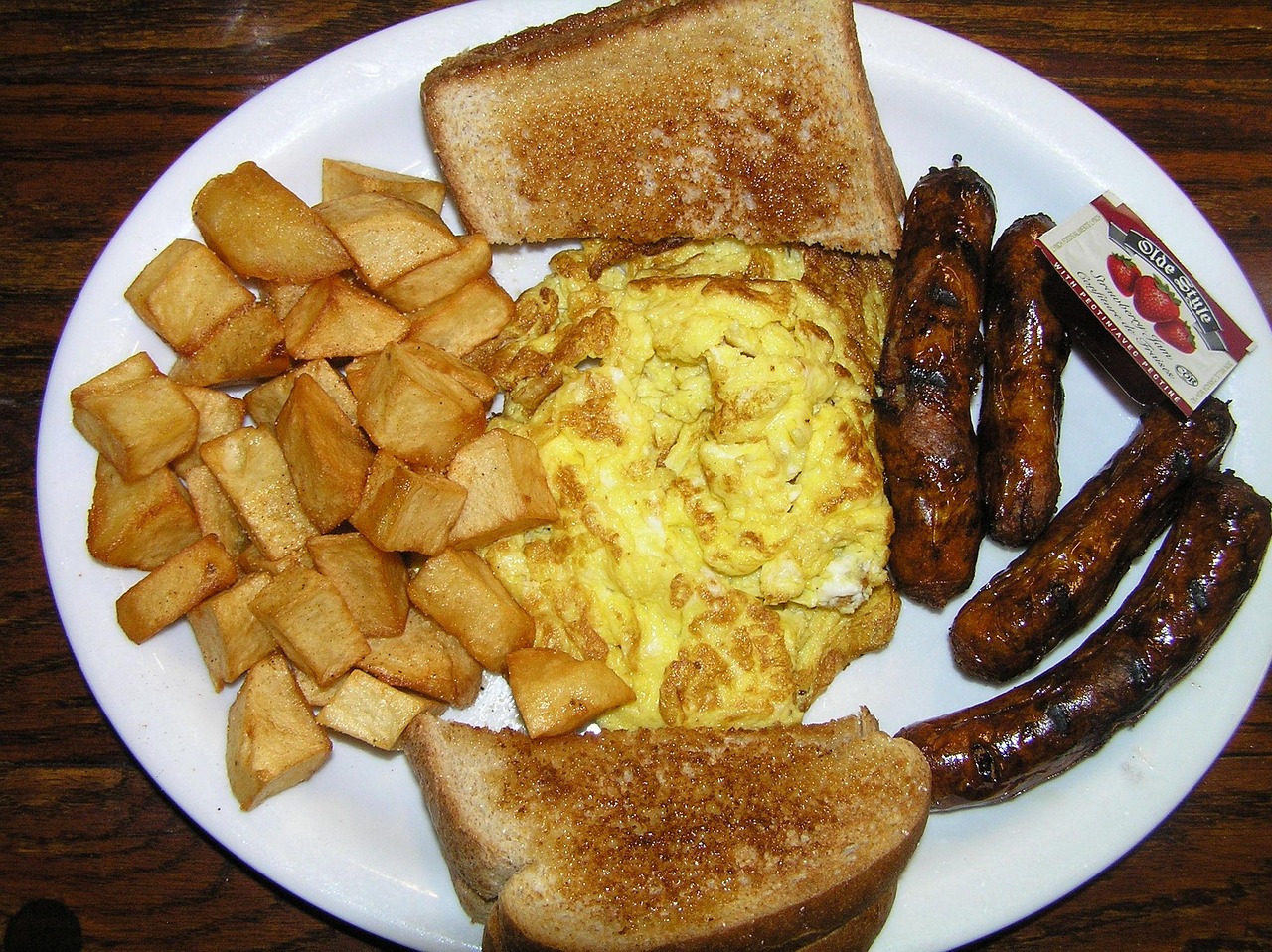 Classic breakfast-for-dinner plate with scrambled eggs, toast, and sausages, quick weeknight dinner idea.